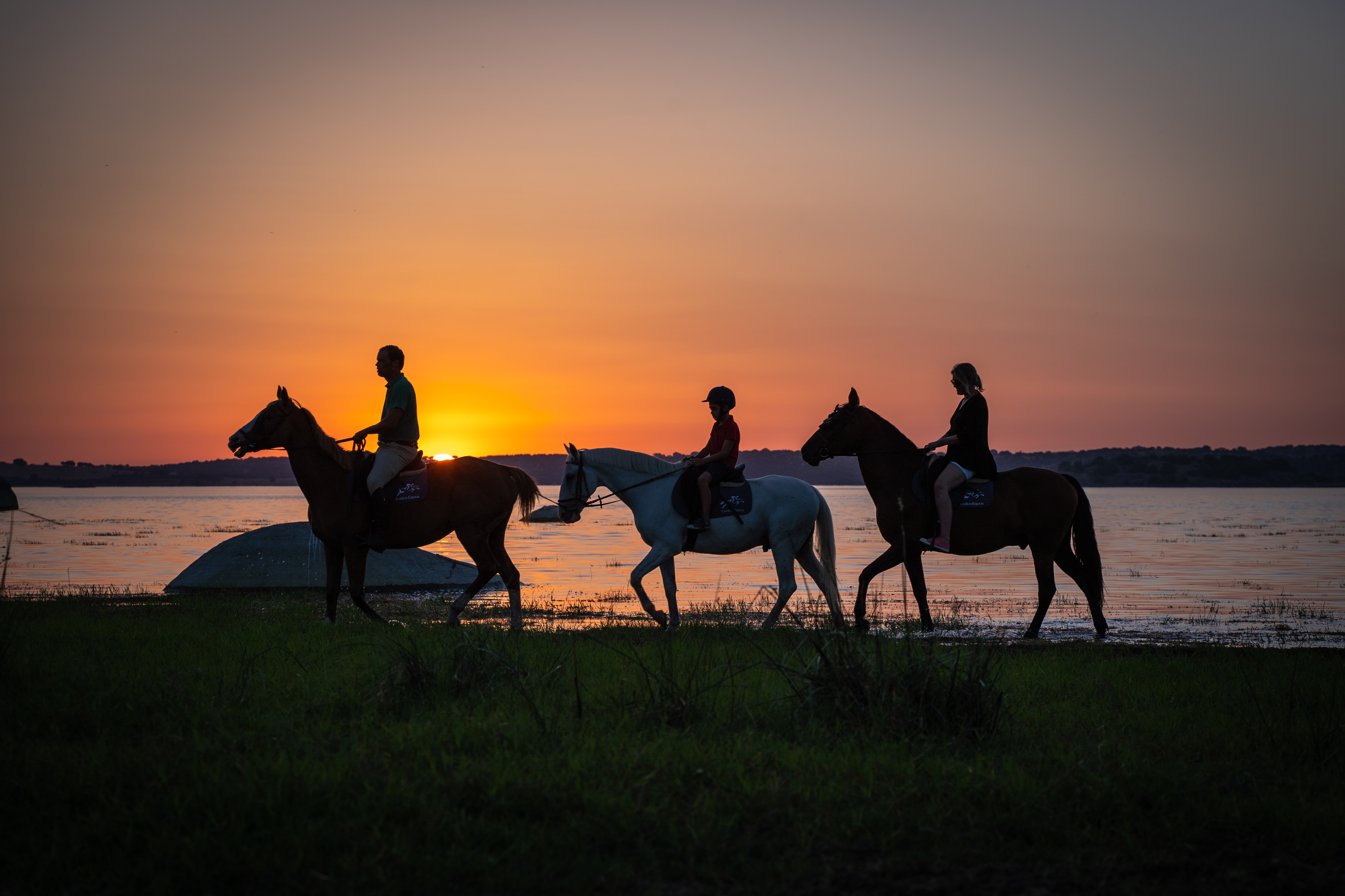 Passeio a cavalo junto à água ao pôr do sol
